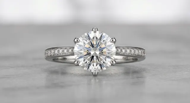 Diamond ring standing upright on white acrylic under diffused studio light